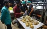 Des employés d'un restaurant préparent des portions de biryani qui seront distribuées dans les quartiers pauvres, le 17 septembre 2023 à Karachi, au Pakistan