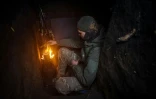 Un soldat ukrainien de la 57e brigade d'infanterie motorisée prépare son repas dans une tranchée près de Bakhmout,le 13 avril 2023 dans la région de Donetsk