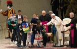 Le pape François, un drapeau ukrainien venant la ville de Boutcha à la main, rencontre de jeunes réfugiés ukrainiens le 6 avril 2022 au Vatican