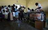 Les citoyens font la queue avant de déposer leurs bulletins de vote, le 25 octobre 2015 à Port-au-Prince