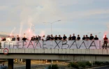 Des personnes rassemblées sur une passerelle d'autoroute tiennent une banderole "Merci, Général", avant le passage du convoi transportant la dépouille du criminel de guerre serbe de Bosnie Ratko Mladić à Belgrade, en Serbie, le 3 septembre 2026
