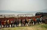 Sur le débarcadère du port fluvial de Bende-Bende, à Maluku en République démocratique du Congo (RDC), des passagers attendent le 20 août 2026 d'être contrôlés, pour éviter la propagation de l'épidémie d'Ebola à la capitale Kinshasa