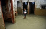 Un enfant dans sa maison inondée par les pluies de mousson, le 26 juillet 2022 à Karachi, dans le sud du Pakistan