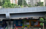Des élèves jouent dans  "l'école du feu rouge", qui accueille des enfants défavorisés dans des conteneurs aménagés en salles de cours sous un pont autoroutier, le 20 mai 2026 à Bombay