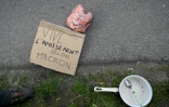Un masque à d'Emmanuel Macron et une casserole sur le bitume lors d'une manifestaion près du château de Joux avant une visite du président, le 27 avril 2023 à La Cluse-et-Mijoux, dans le Doubs