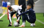 L'attaquant des Bleus Kylian Mbappé scrute l'échauffement de ses coéquipiers avant de débuter sur le banc contre le Kazakhstan à Nur-Sultan, le 28 mars 2021