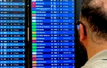 Un voyageur regarde des panneaux d'informatino sur les vols lors d'une panne des systèmes de contrôle aérien à l'aéroport de Paris-Orly, au sud de Paris, le 18 mai 2025