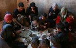 Une famille partage un maigre repas à base de choux et de maïs dans la Ghouta orientale assiégée près de Damas, le 6 novembre 2017
