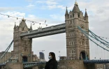 Une femme portant un masque traverse le Tower Bridge à Londres le 1er novembre 2020 alors que l'Angleterre se prépare à de nouvelles restrictions