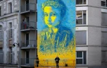Le street-artiste français C215 devant la fresque représentant une fillette aux couleurs du drapeau ukrainien qu'il a peinte à Paris, le 10 mars 2022