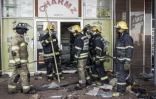 Les pompiers sud-africains devant un centre commercial dévalisé à Vosloorus, dans la banlieue de Johannesburg, Afrique du Sud, le 14 juillet 2021