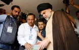Le leader chiite irakien Moqtada al-Sadr (R) vote lors des élections législatives dans la ville de Najaf, dans le centre de l'Irak, le 12 mai 2018