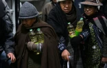 Des habitants repartent avec des bouteilles d'huile achetées dans un magasin Emapa à prix réduit, le 11 juin 2025 à La Paz, en Bolivie