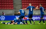 Le milieu de terrain slovaque Robert Mak (à terre), félicité par ses coéquipiers, après son but marqué contre la Russie, lors de leur match de qualification pour le Mondial-2022, le 30 mars 2021 à Trnava (Slovaquie)