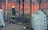 Un pompier ukrainien éteint un incendie dans un hypermarché après une frappe russe à Kharkiv, le 25 mai 2024