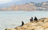 Des migrants regardent la mer à Vintimille, à la frontière franco-italienne, tout près de la ville française de Menton, en arrière-plan, le 13 juin 2015