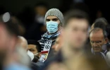 Un amateur de football, le visage couvert d'un masque de protection contre le coronavirus, assiste au match de l'Olympique lyonnais contre la Juventus Turin en huitième de finale aller de Ligue des champions, à Lyon (France) le 26 février 2020