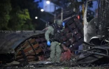 Un policier inspecte la carcasse d'un véhicule après l'explosion d'un camion bourré d'explosif près d'un commissariat de police dans la ville colombienne de Cúcuta, près de la frontière avec le Venezuela, le 1er août 2026
