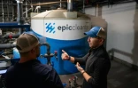 Le patron d'Epic Cleantec Aaron Tartakovsky (d) et Ryan Pulley (g), directeur des opérations de recyclage, devant la machine permettant de purifier l'eau usée d'un immeuble, le 26 septembre 2023 à San Francisco