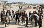 Des Palestiniens portent le corps d'un homme tué lors d'une distribution d'aide humanitaire près du camp de réfugiés de Nousseirat, dans le centre de la bande de Gaza, le 2 août 2025