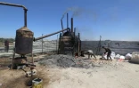 Un réservoir relié à une cuve permet l'extraction de carburant de produits en plastique dans la bande de Gaza, le 23 août 2022