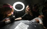 Une femme profite du festival "Art Weapon" à Kiev pour se faire tatouer, le 14 mai 2022