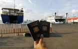 Un Syrien montre ses passeports syriens en attendant le ferry à Tripoli au Liban qui va le conduire en Turquie, le 6 octobre 2015