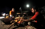 Des randonneurs et leur guide dînent à la belle étoile près du cratère volcanique d'Al Wahbah, à quelque 360 km de Jeddah, en Arabie saoudite, le 17 novembre 2017