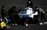 Des membres de l'équipe sud-coréenne KAIST, poussent leur voiture de course autonome, après qu'elle a fait un tête à queue, le 7 janvier 2022 à Las Vegas