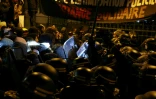 Une foule s'oppose aux autorités après qu'un ordre de la police a été donné d'évacuer la Gaîte Lyrique, une salle de spectacle parisienne occupée pendant trois mois par 450 jeunes migrants, à Paris le 18 mars 2025