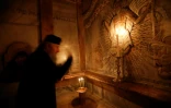 Un ecclésiastique dans le tombeau où le Christ a été enterré selon la tradition, dans l'église du Saint-Sépulcre à Jérusalem, le 21 mars 2017