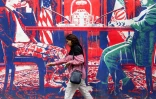 Une personne passe devant une fresque sur l'ancienne ambassade américaine à Téhéran, le 8 avril 2025 