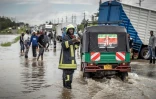 Un pompier sur une route inondée après à des pluies torrentielles à Kitengela, le 1er mai 2024 au Kenya