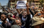 Un manifestant brandit une pancarte critique du président malgache et du président français lors d'un rassemblement à Antananarivo le 14 octobre 2025