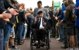 Un vétéran britannique est applaudi par des habitants après une cérémonie au cimetière de Colleville-sur-Mer, près d'Omaha Beach, le 4 juin 2019