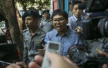 Le journaliste birman Wa Lone (c) escorté par des policiers après son procès à Rangoun, le 4 avril 2018