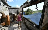 Galyna Kios montre l'étendue des dégâts à son domicile dans le village ukrainien de Mala Rogan, proche de la frontière russe et théâtre de combats acharnés, le 28 juillet 2022