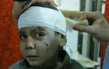 Un enfant syrien est soigné dans une clinique de fortune à Kafr Batna après des bombardements du régime sur les zones rebelles dans la Ghouta orientale, le 6 mars 2018 