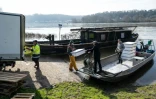 Des pêcheurs chargent des boîtes contenant des civelles sur leur bateau à Saint-Martin-de-la-Place, le 14 février 2025 en Maine-et-Loire