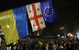 Des drapeaux ukrainien, géorgien et européen déployés à Tbilissi, le 30 novembre 2024, lors d'une manifestation contre la décision du gouvernement géorgien de retarder les négociations d'adhésion à l'Union européenne jusqu'en 2028