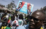 Un partisan brandit une affiche avec le candidat présidentiel sénégalais Bassirou Diomaye Faye et le leader de l'opposition Ousmane Sonko lors d'un rassemblement à Dakar le 10 mars 2024