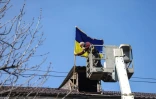 Un employé municipal remet le drapeau ukrainien sur le toit de la mairie à Boutcha, en Ukraine, le 7 avril 2022