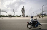 Un motocycliste passe devant la statue de l'Amazone à Cotonou (Bénin), le 8 décembre 2025