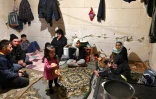 Des familles de migrants afghans vivent dans une maison abandonnée, le 30 janvier 2021 à Bosanska Bojna, à la frontière entre la Croatie et la Bosnie