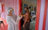 Un soignant administre un vaccin à Joao Aquino Filho (D), 71 ans, près de Manaus en Amazonie au Brésil le 9 février 2021