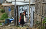 Une habitante étend du linge dans le bidonville la "Cité de Dieu", dans le quartier du Mont Sinai à Guayaquil, le 26 juillet 2022 en Equateur