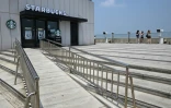Des touristes observent la Corée du Nord depuis un point de vue à proximité d'un Starbucks située à l'Écoparc de la Paix d'Aegibong, à Gimpo, en Corée du Sud, le 1er juillet 2026 
