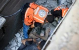 Des secouristes et des civils retirent le corps d'un homme sous les gravats après une frappe israélienne sur le camp de réfugiés de Nousseirat, dans le centre de la bande de Gaza, le 6 juillet 2024