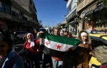 Des enfants syriens agitent le drapeau aux trois étoiles, symbole du soulèvement de 2011, à Damas le 15 décembre 2024
