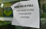 Une feuille de papier scotchée sur la vitre d'un abri indiquant que le centre d'accueil est plein dans la station balnéaire de Naples, dans le sud-ouest de la Floride frappée par l'ouragan Irma, le 9 septembre 2017  